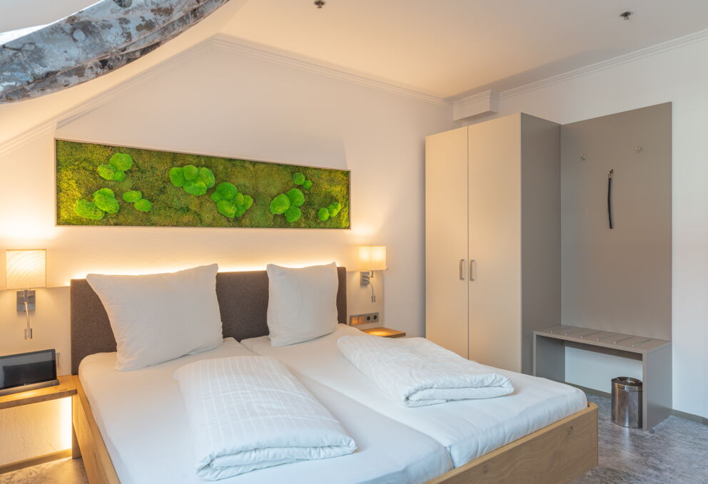Doppelbett mit Schrank und Bild im Greenwing Zimmer