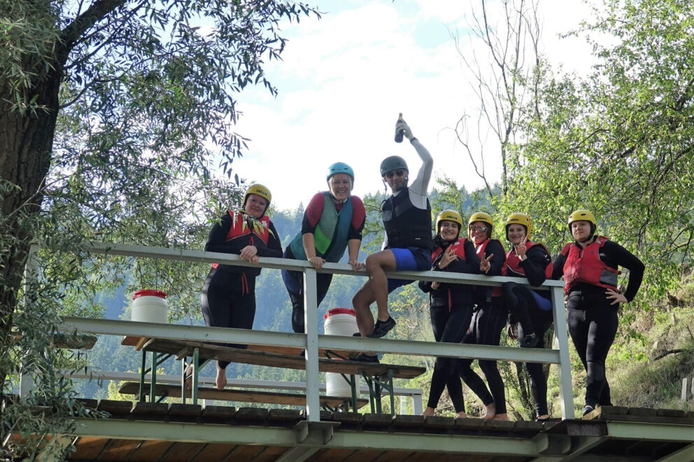 Gruppe von Wassersportlern in einem Neoprenanzug und einer Schwimmweste.