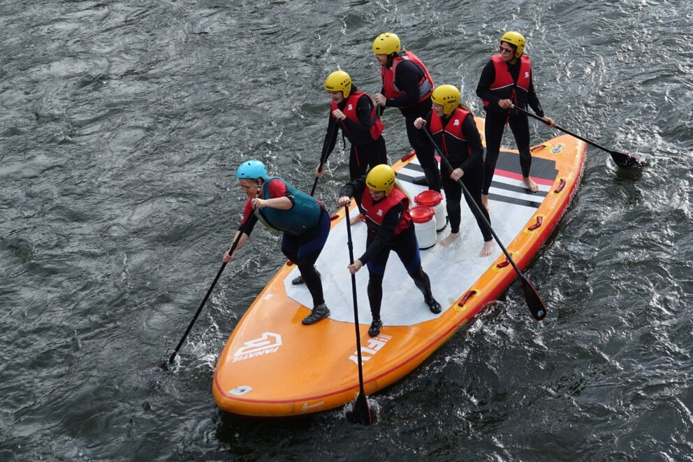 Eine Gruppe von Sportlern auf einem Stand Up Paddle auf der Mur