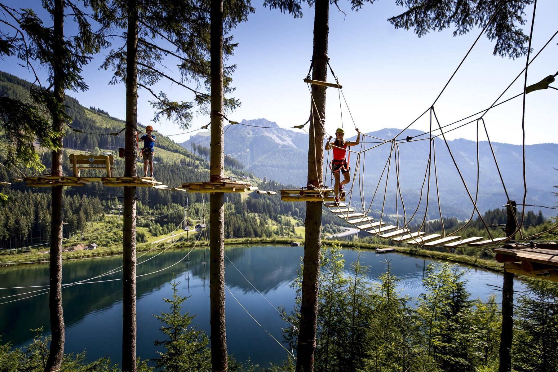Zwei Personen im Hochseilgarten im Adventurepark Präbichl mit Blick auf den Grüblsee (c) Tom Lamm