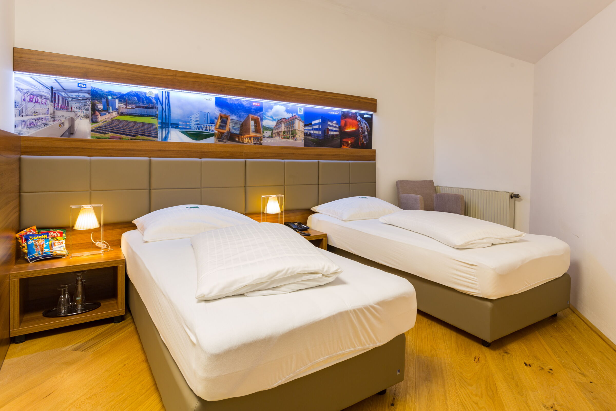 zwei twin sized Betten im Business Zimmer und einem Sessel in der Ecke