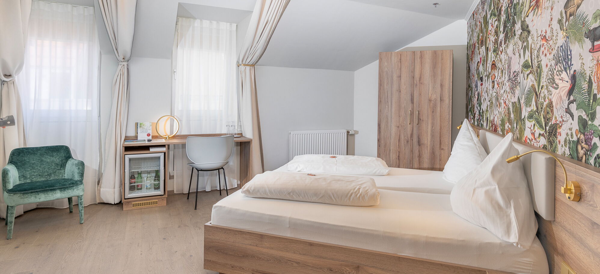 2025 newly renovated comfort room at Hotel Kongress Leoben with double bed, desk and upholstered armchair