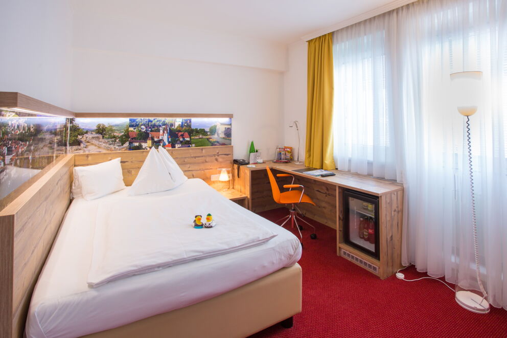 Zimmer mit 2 Gummi-Enten auf dem Bett