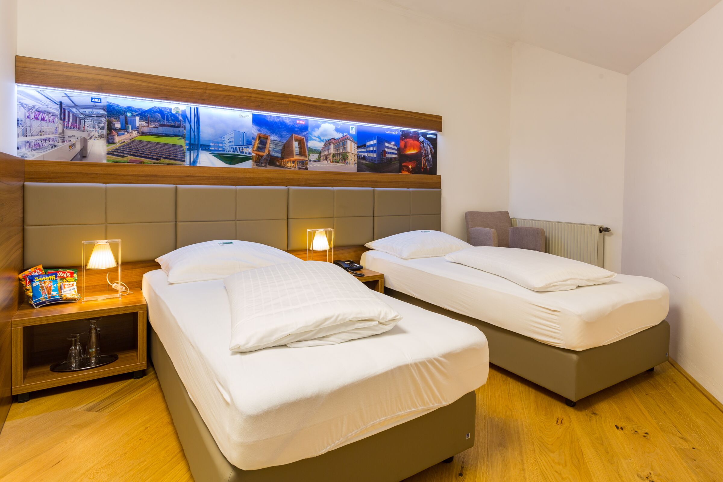 zwei twin sized Betten im Business Zimmer und einem Sessel in der Ecke