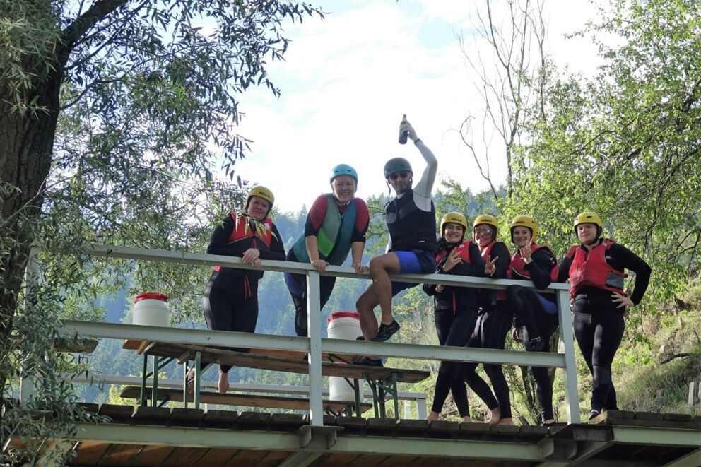 Gruppe von Wassersportlern in einem Neoprenanzug und einer Schwimmweste.