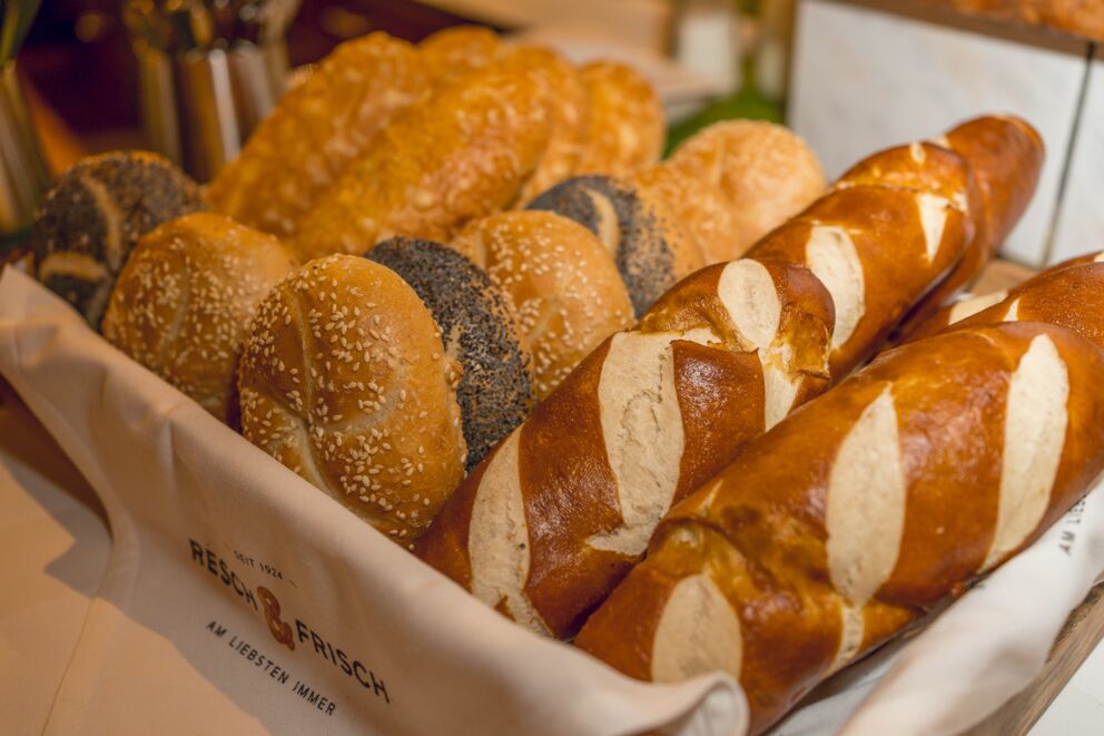 Brotkorb mit selbstgebackenen Laugenstangen, Mohn- und Sesambrötchen